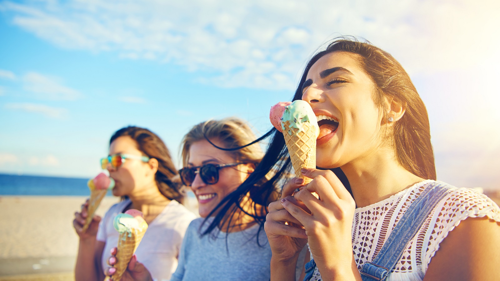 Three young woman eating ice cream cones
