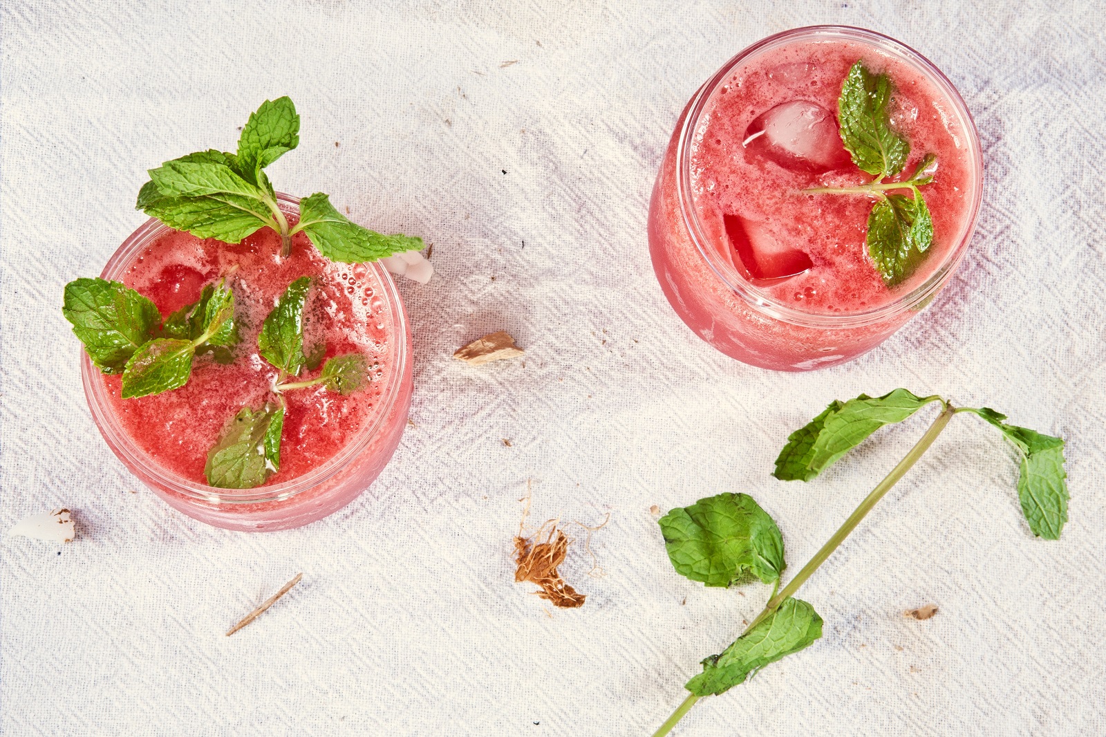 strawberry cocktail with ice and mint leaves on white background