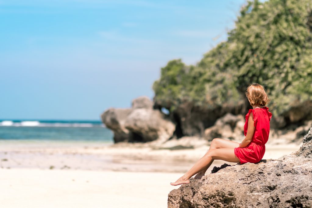 Girl sitting on the beach in the sun
