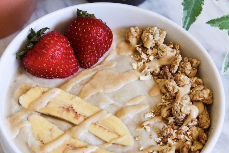 peanut butter banana smoothie bowl with strawberries and granola