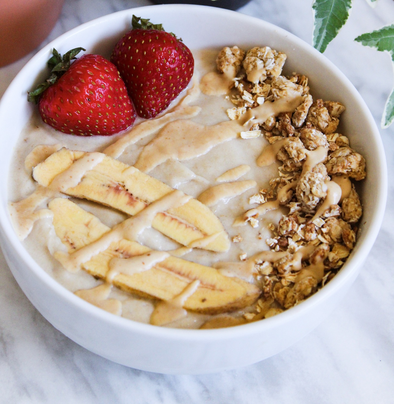 peanut butter banana smoothie bowl with strawberries and granola