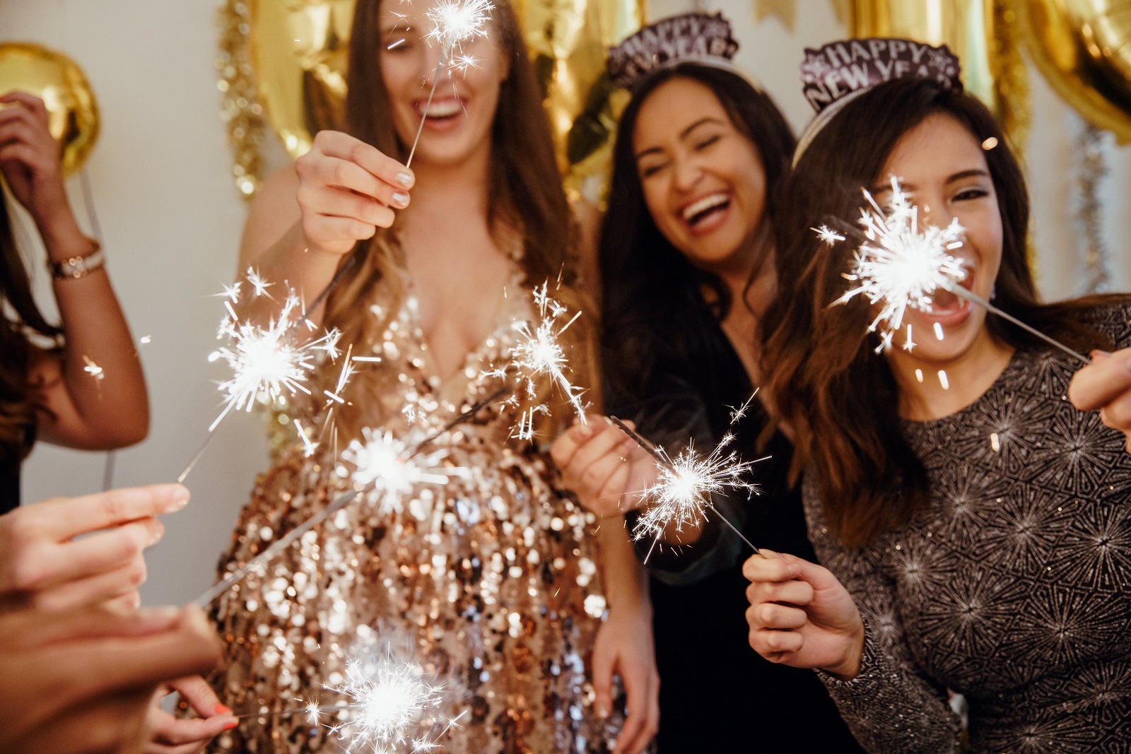 group of women with sparklers celebrating New Year's
