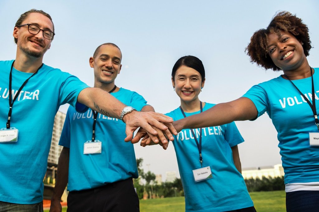 four people wearing blue t-shirts saying Volunteer