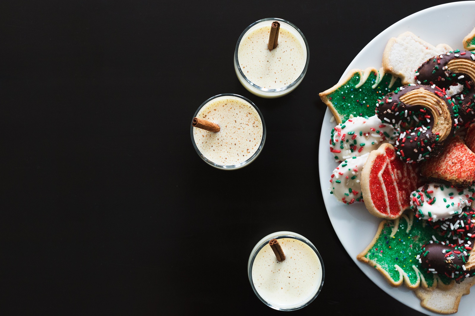 three eggnogs with a plate of Christmas cookies