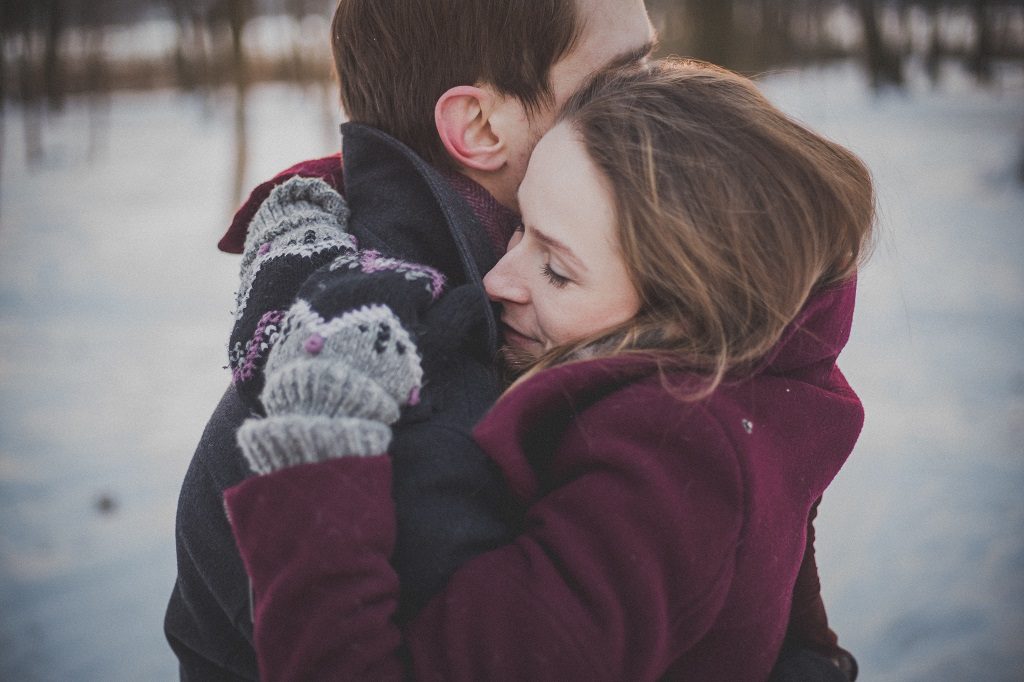 young couple hugging in winter landscape