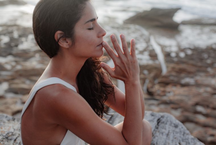 woman meditating on the beach