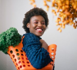 woman with shopping basket using a plant based grocery list
